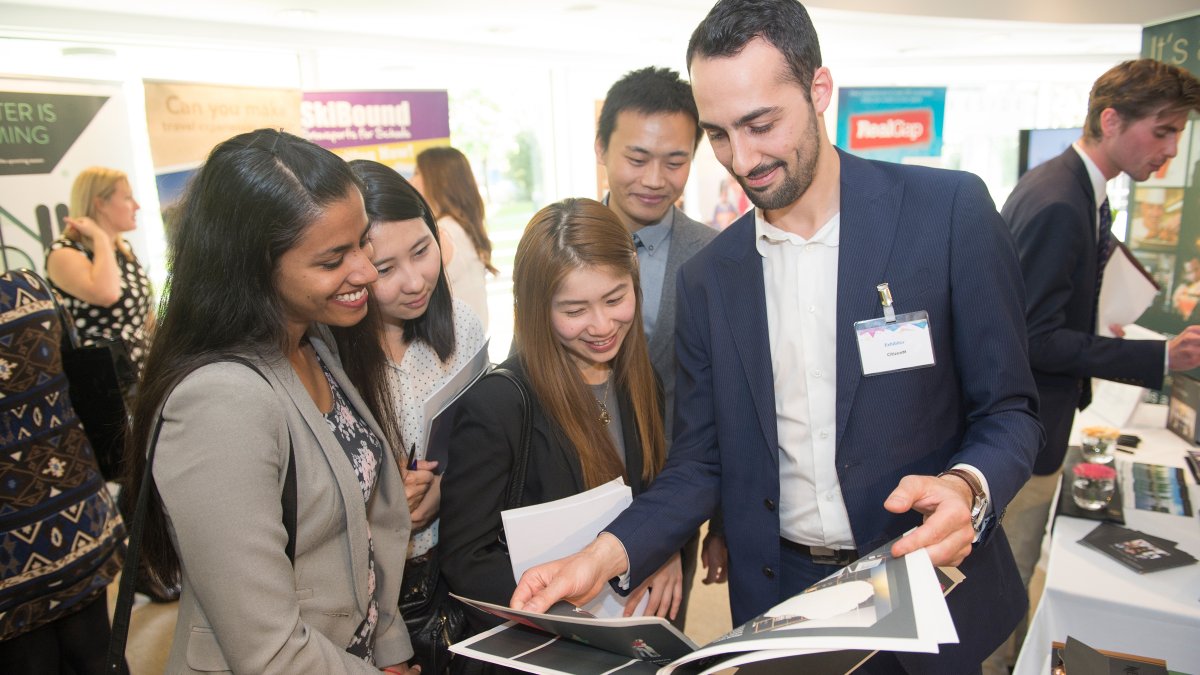 Group of students talking to prospective employer