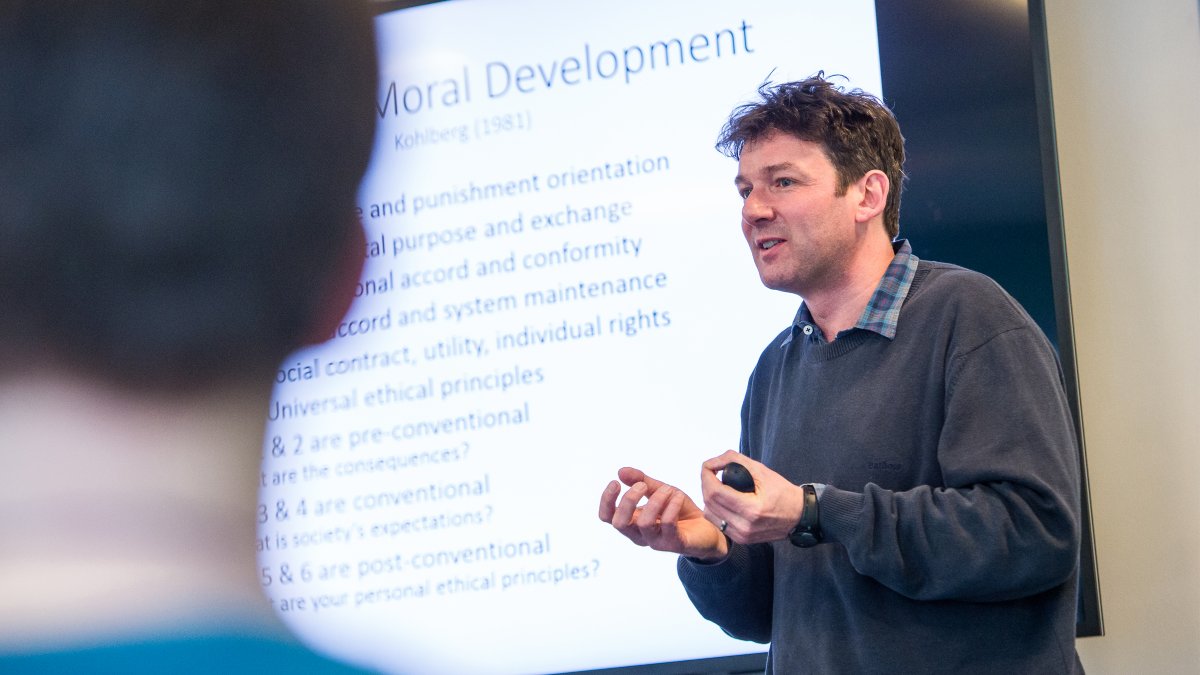 A man giving a lecture in front of a whiteboard