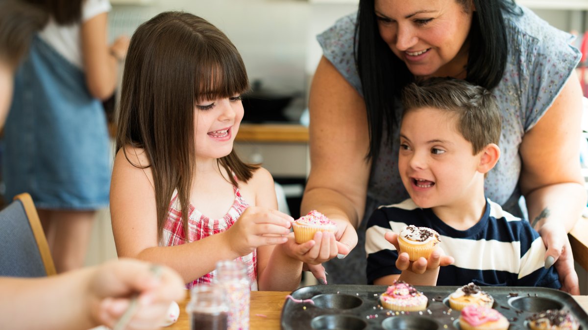 Children decorating cupcakes with their mum