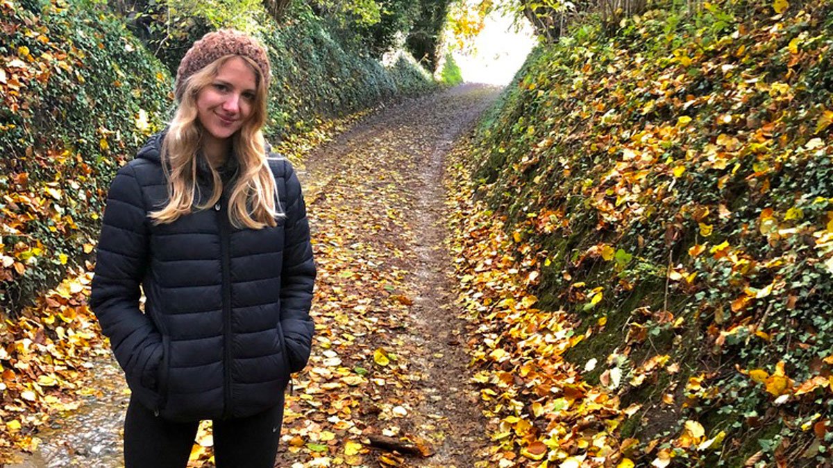 Emily Baynes standing on a country lane in autumn