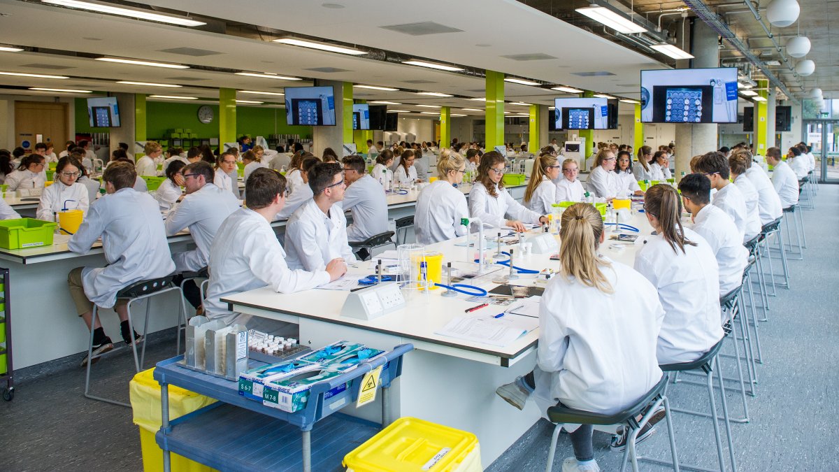 Students sitting in a lab looking at a TV screen
