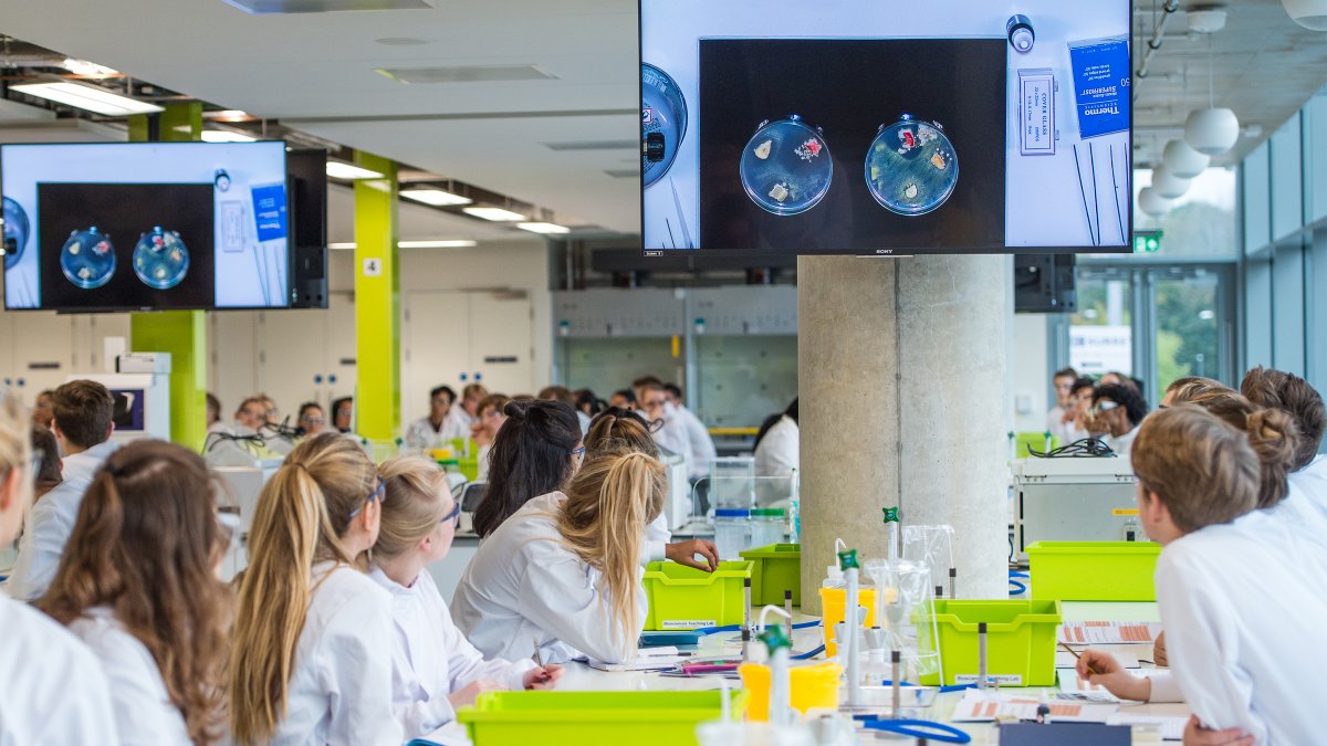 Students in a laboratory looking at a TV screen