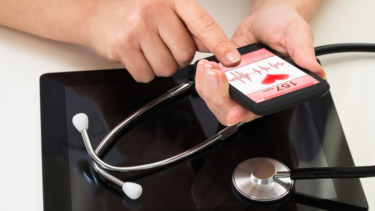 Person holding mobile with heart data on screen