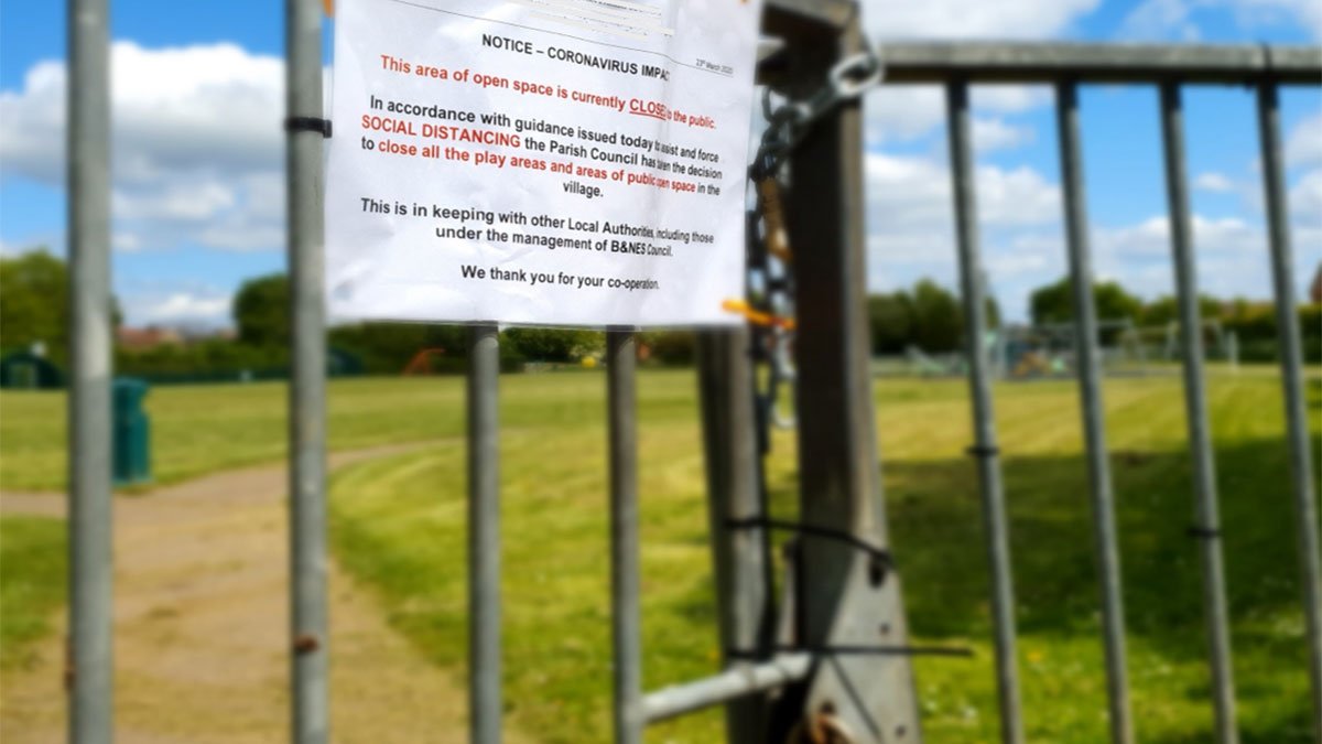 A locked gate with a Covid-19 notice