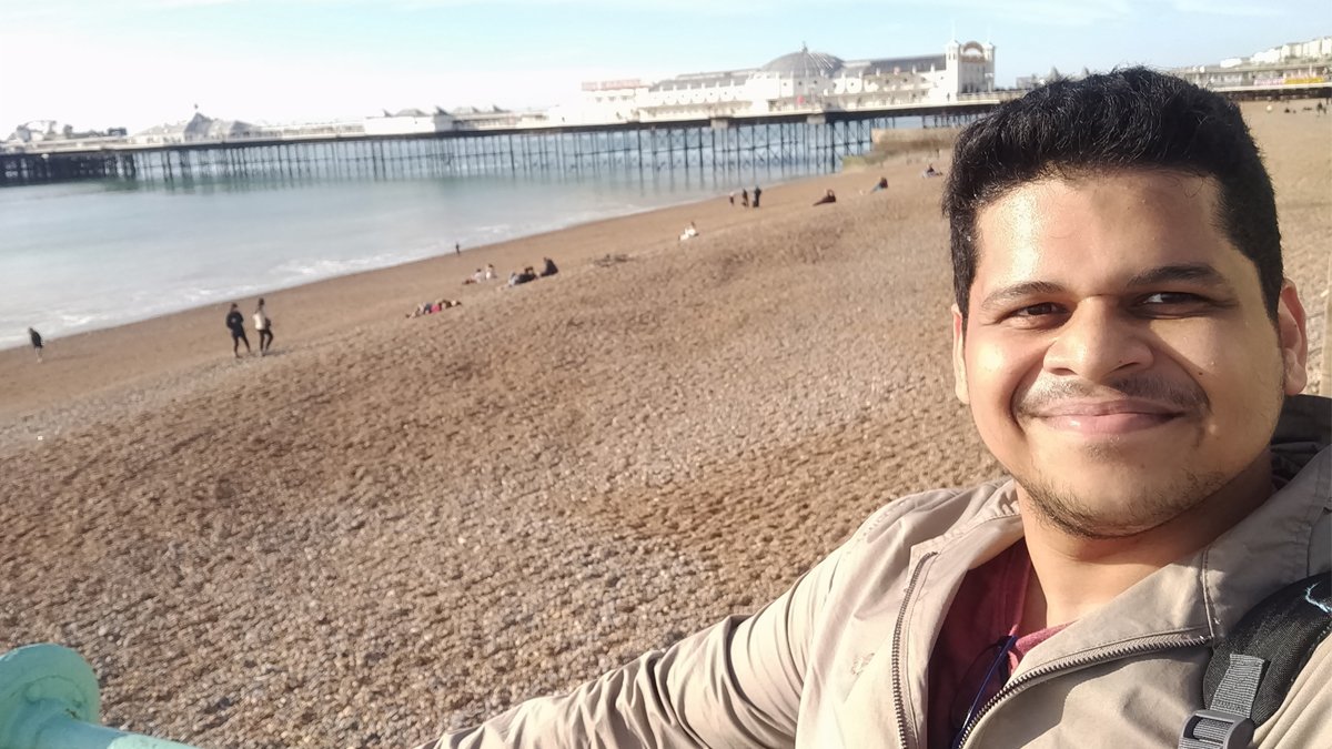 Dr Akshay Alawani standing by Brighton beach
