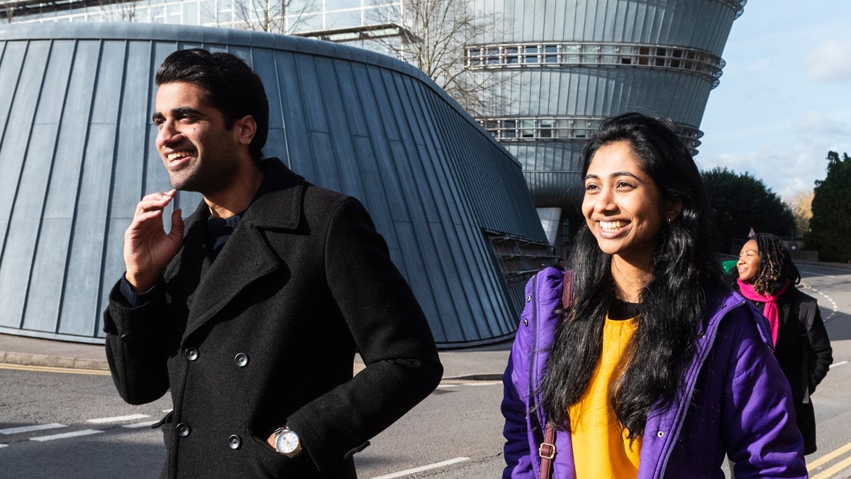 Three students walking by the Duke of Kent Building