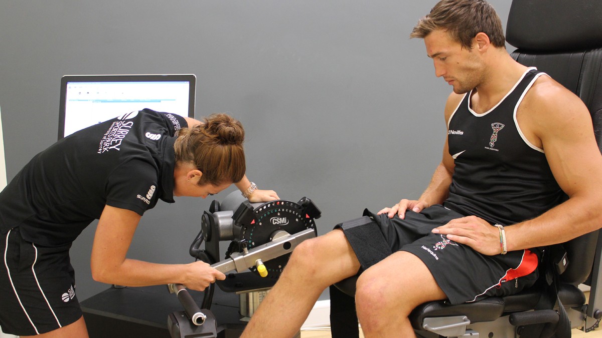 A woman carrying out a fitness assessment on a sports person
