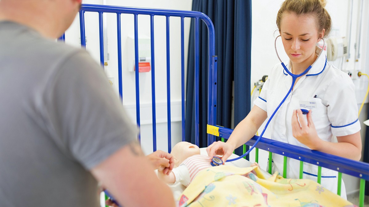 Student nurse checking heartbeat of child mannequin