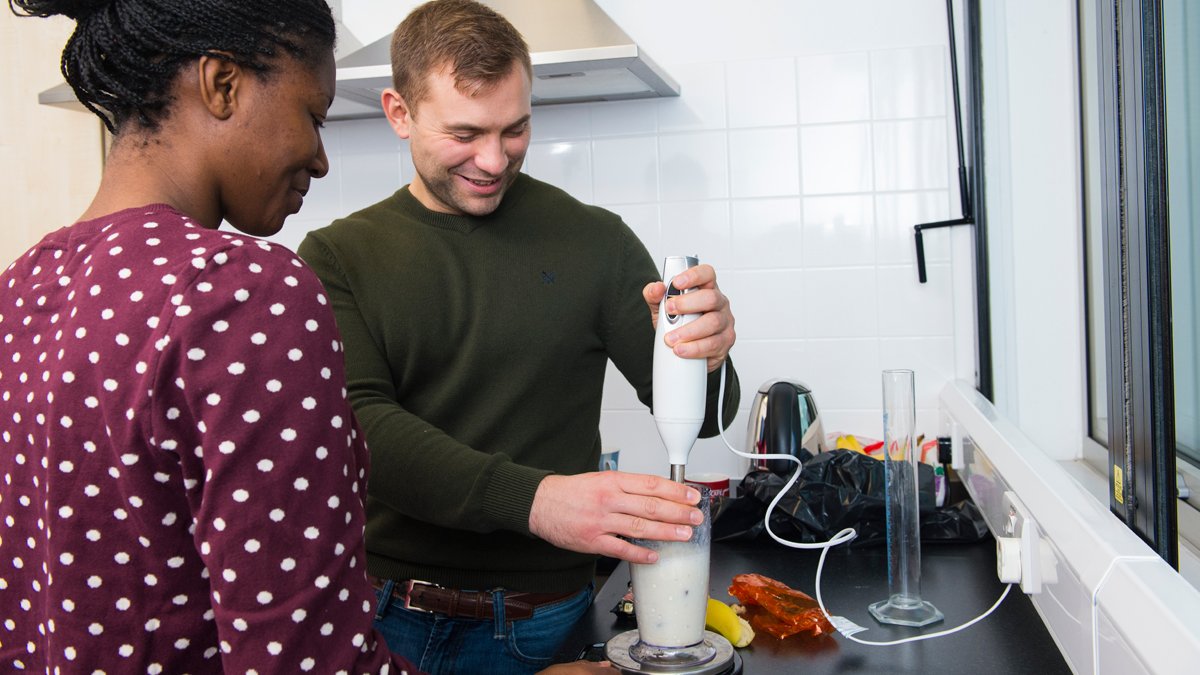 Student using a hand blender to make a smoothie