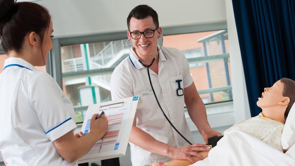 Student nurse checking breathing on adult mannequin