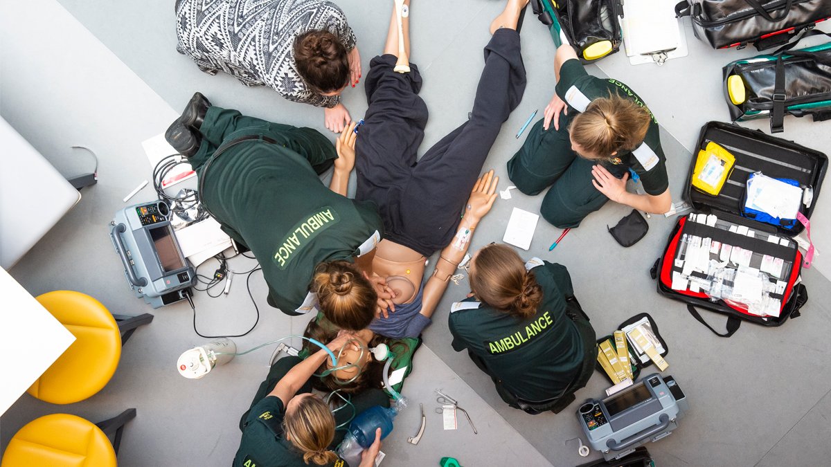 Birdseye view of trainee paramedics providing treatment to a medical manikin