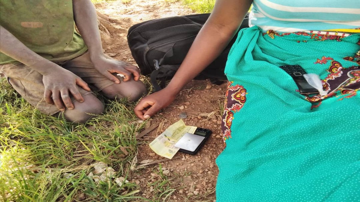 Woman organises money on the ground 
