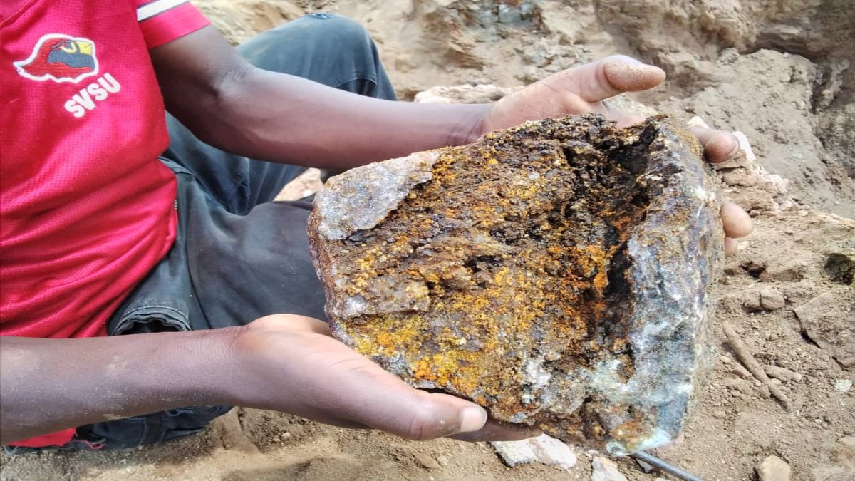 Man holds extracted material from panning 