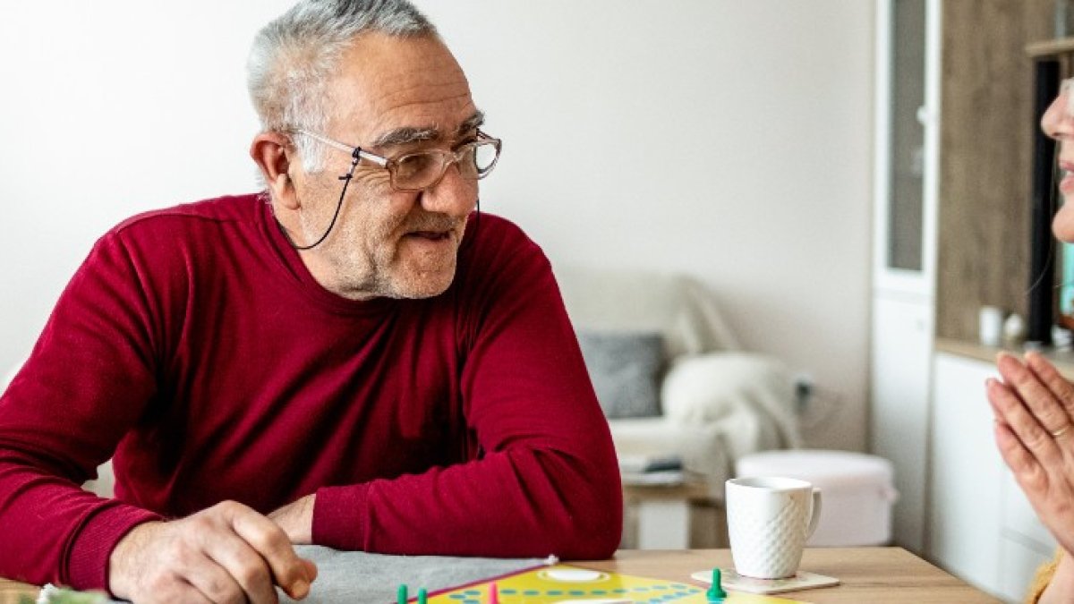 Two elderly people play a board game together