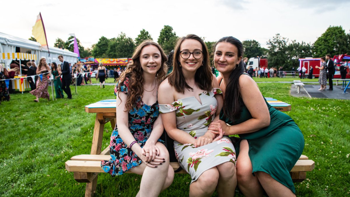 Three students sitting on a bench at Graduation Ball