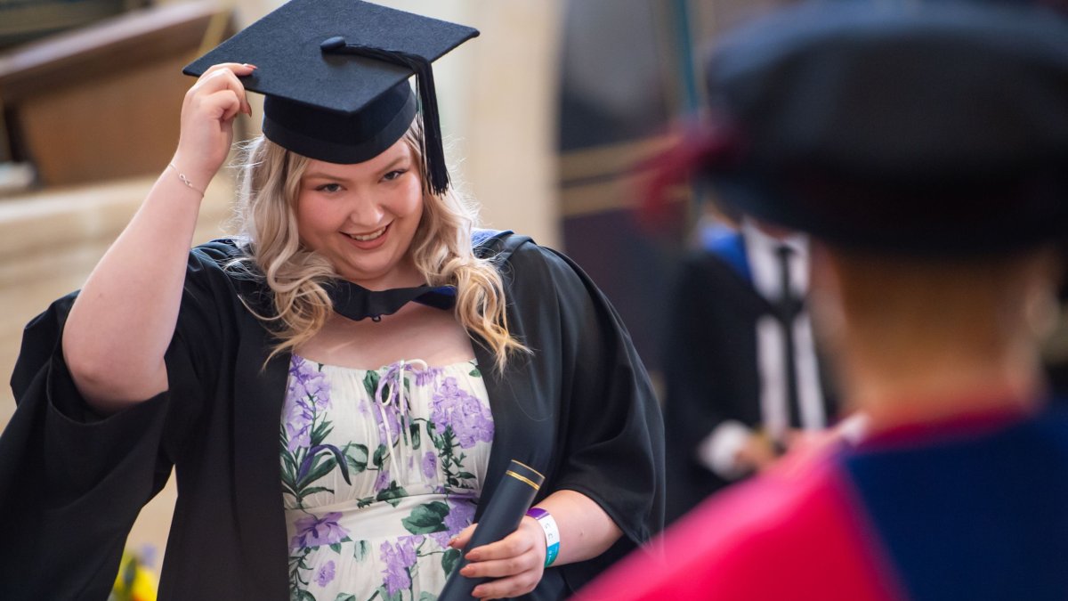 A graduand doffing their cap
