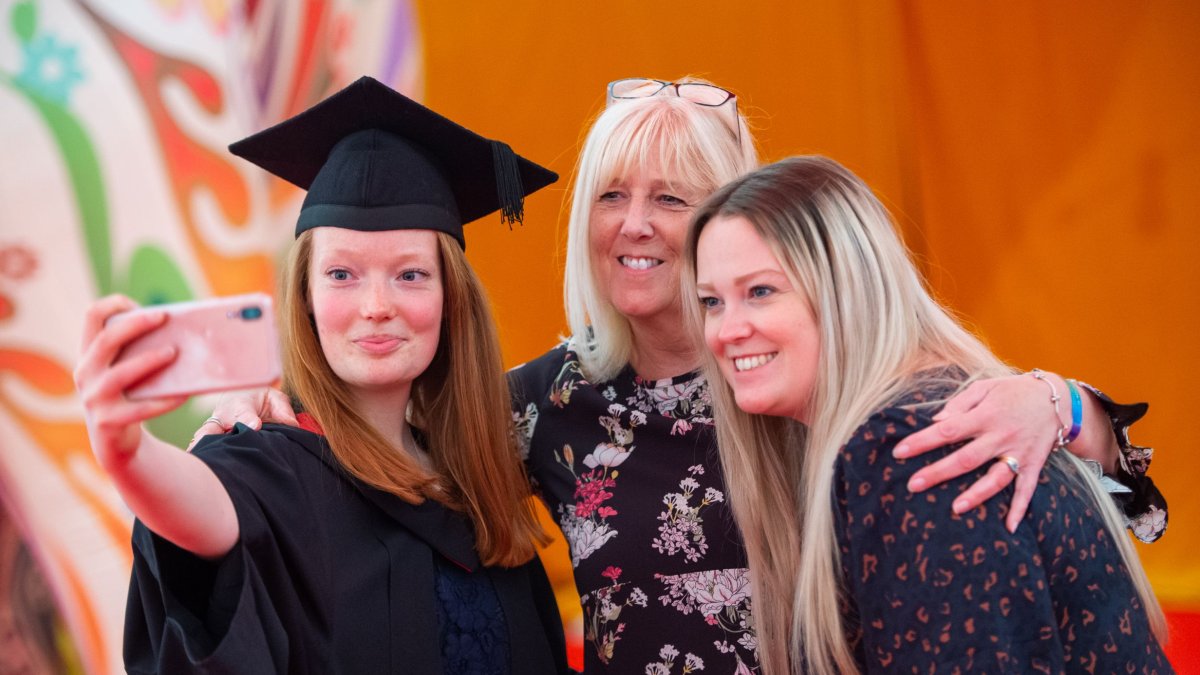 A graduate and their guests taking a selfie