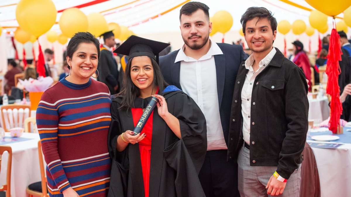 A photo of a family standing with their graduate