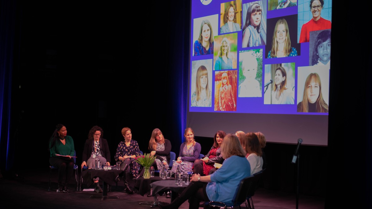 women on stage with images in the background