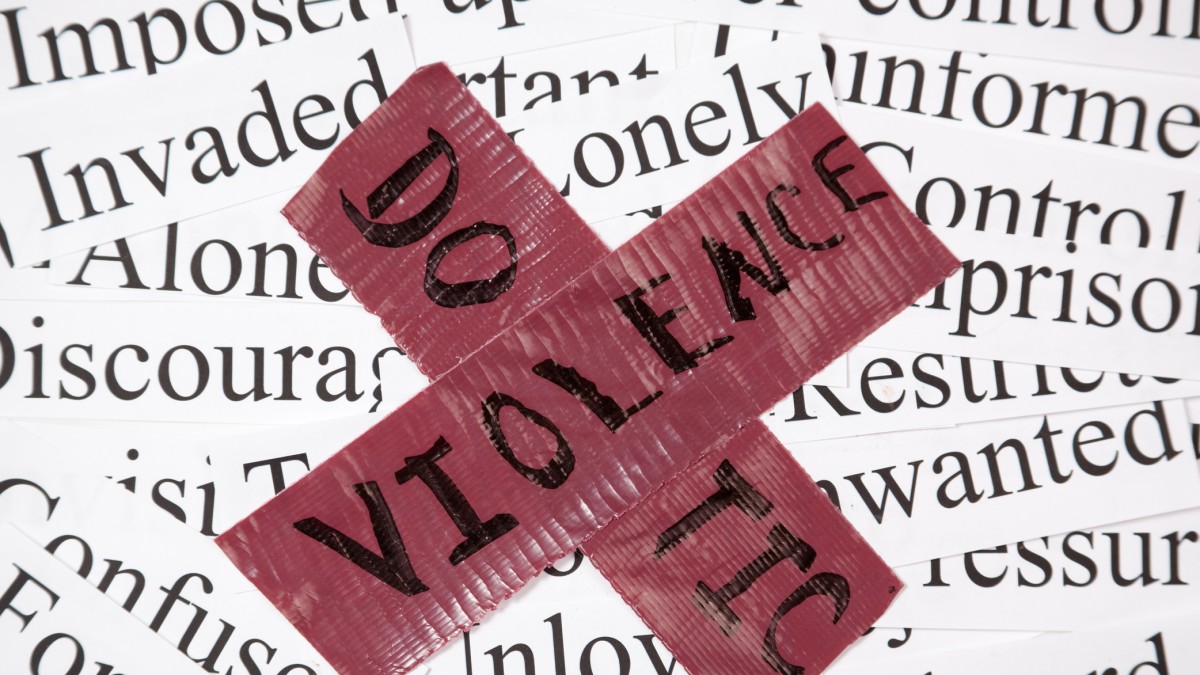 red cross with text domestic violence against a word cloud backdrop