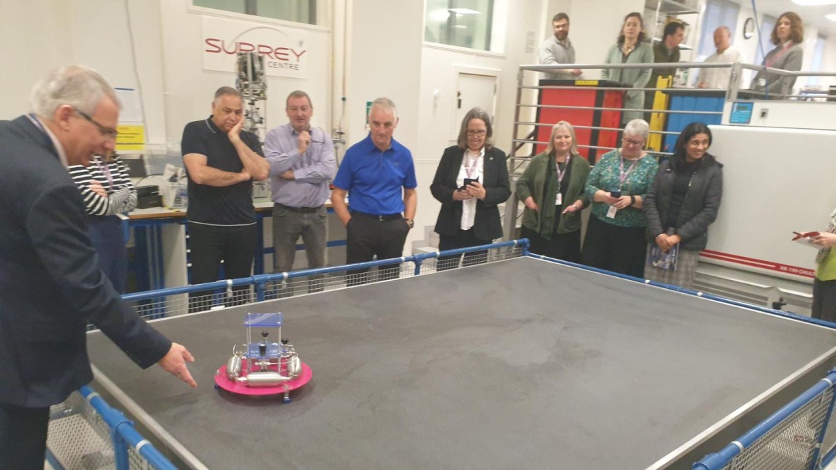 Staff from Alton College watch a demonstration on Surrey Space Centre's air bearing table