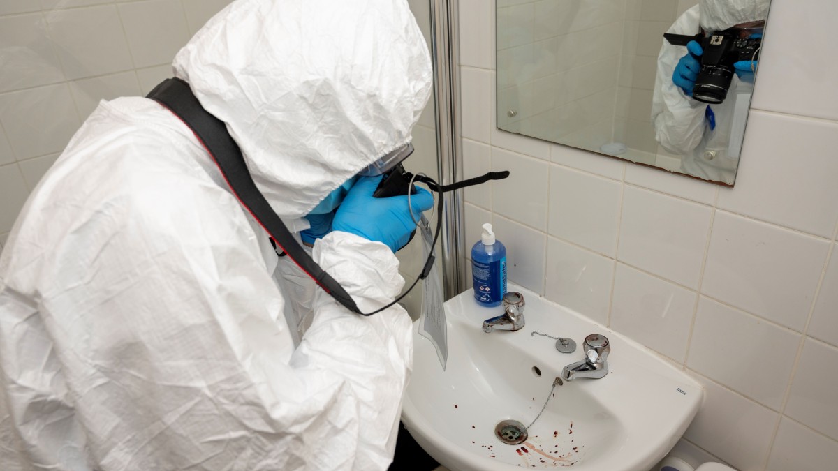 Student investigation blood spatters in sink in crime scene flat