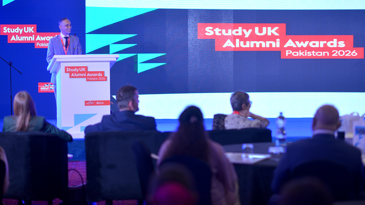 A photograph of alumnus Aon Bukhari accepting his award.