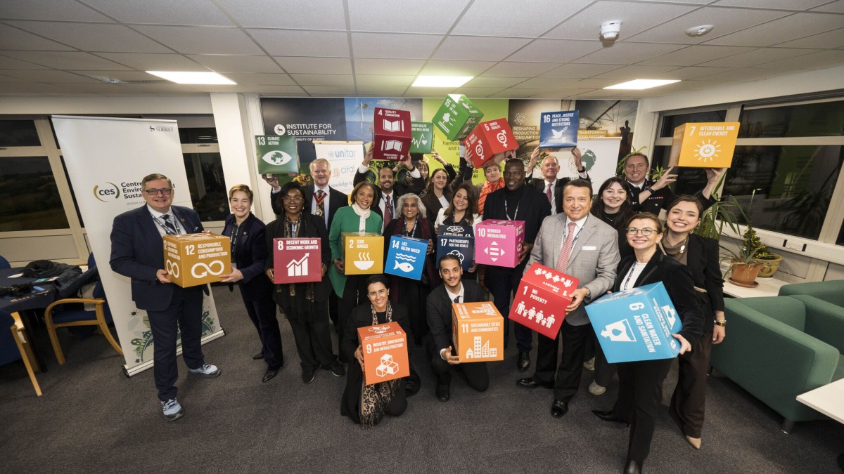 staff and academics inside a university room holding boxes of each of the UN's Sustainable Development Goals