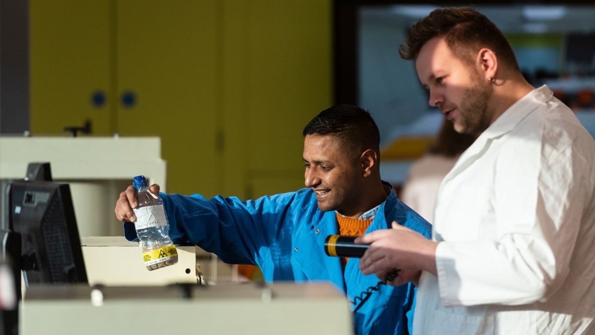 Two students in lab coats in the Surrey radiation laboratory