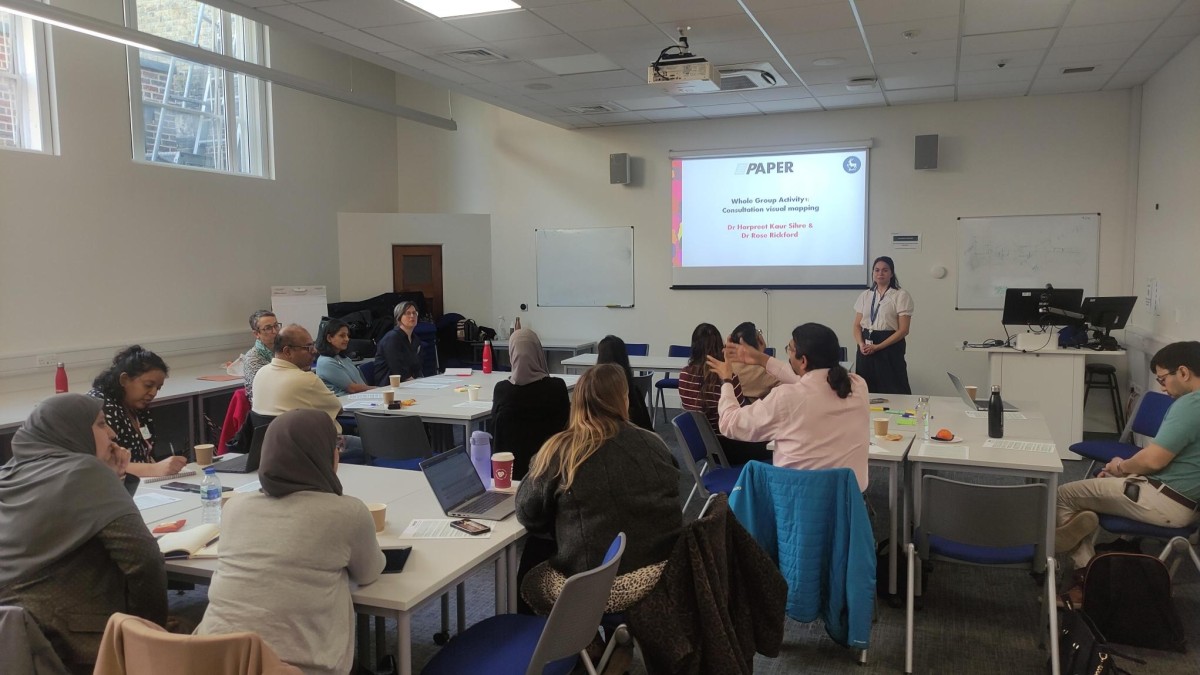 Groups of people sit at tables having a discussion.