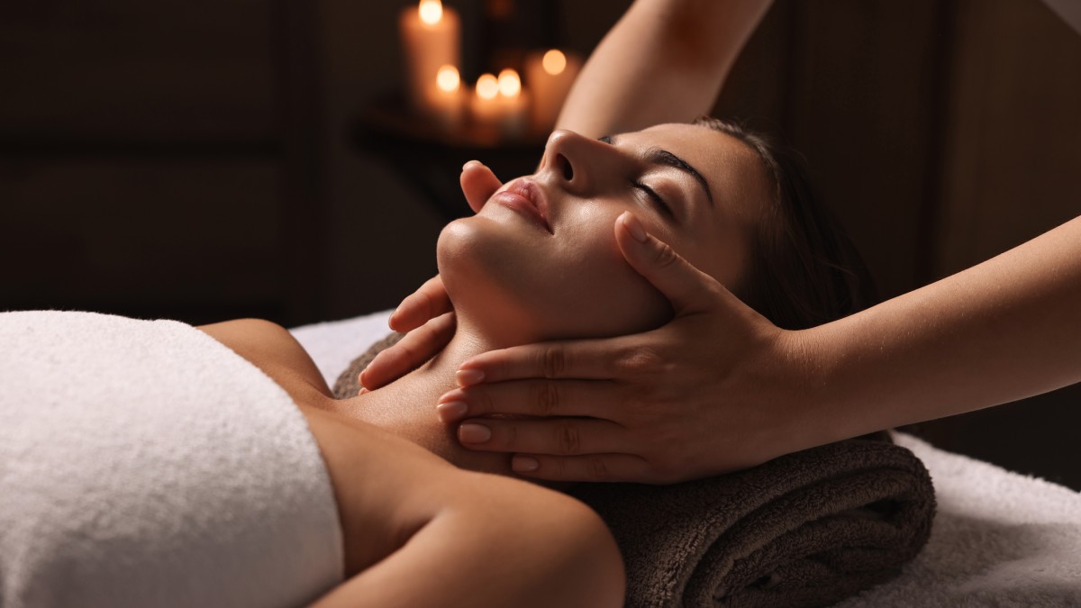 A woman at a spa receiving a neck massage