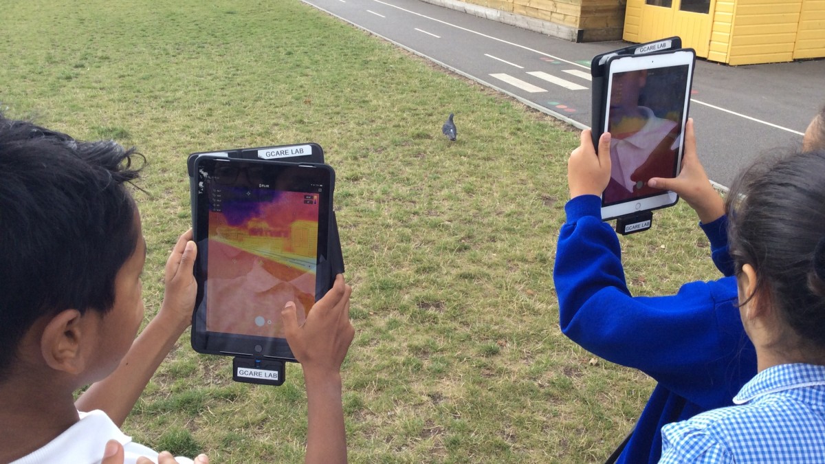 Children holding up digital pads with thermal imaging