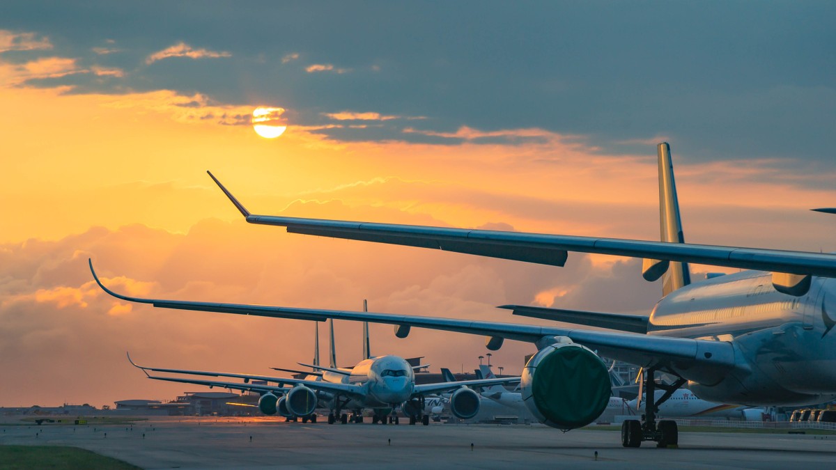 planes lined up at an airport runway