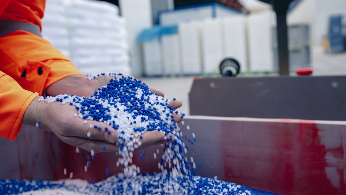 Plastic granules are poured from the hand 