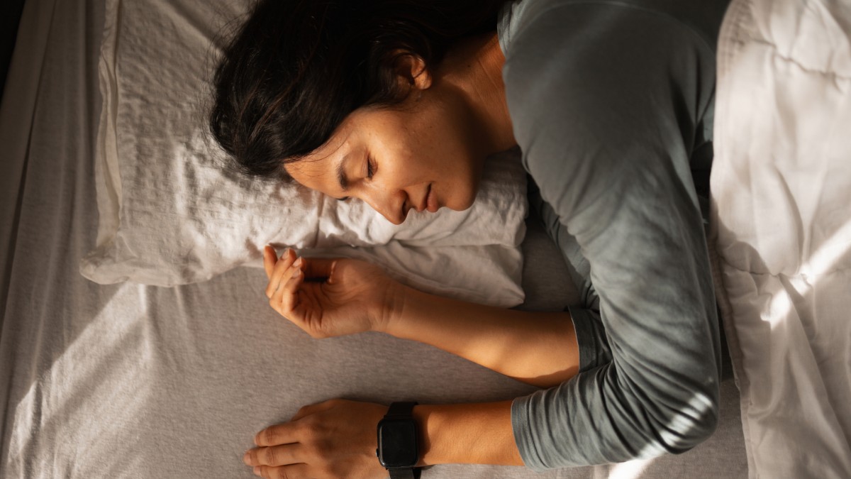 woman sleeping peacefully in bed with a smartwatch on her wrist