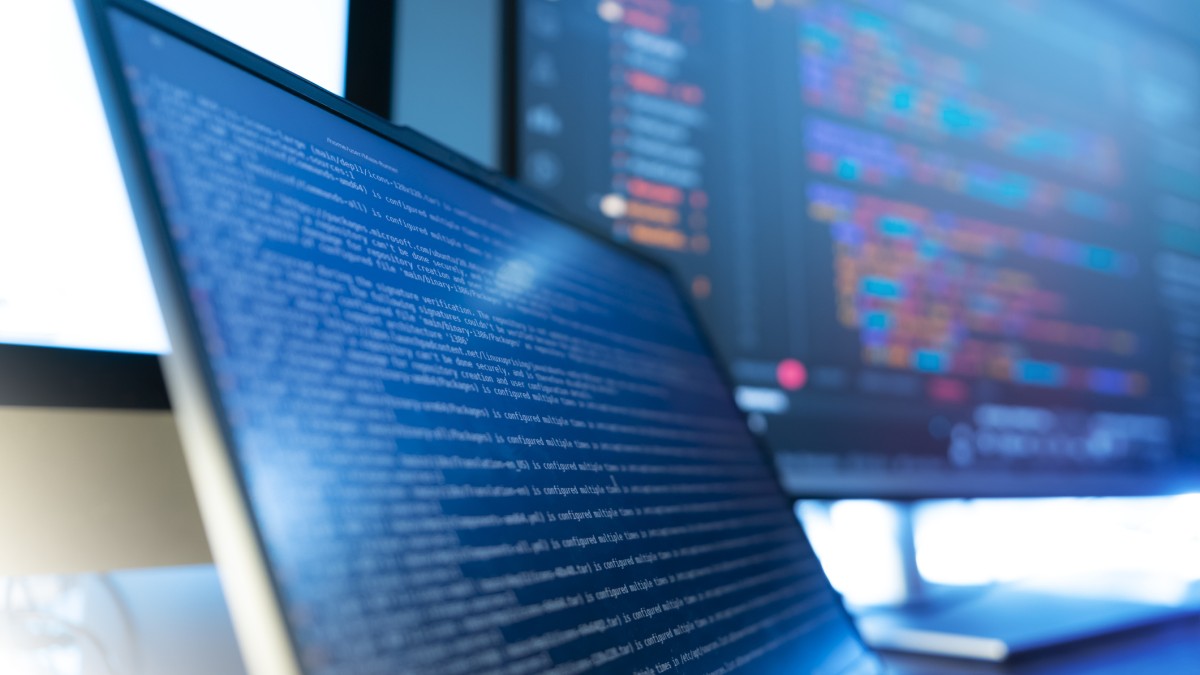 Laptop and monitor showing coding