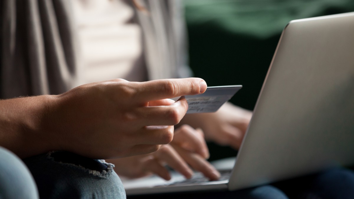 Man holding laptop and payment card
