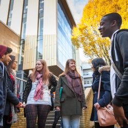 Students standing talking to each other outside the Surrey library