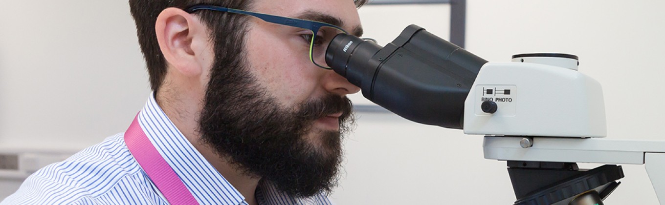 A man is looking into a microscope