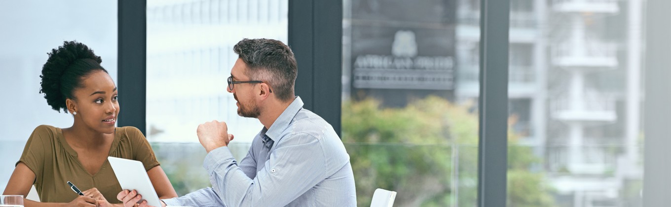 Male and female talking around table