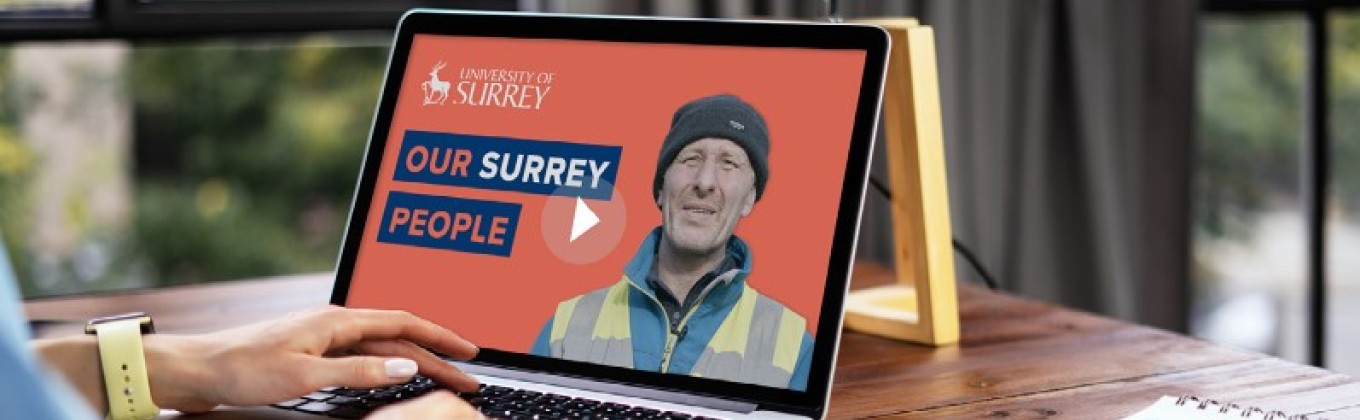 A person is looking at a laptop with an Our Surrey People video on the screen.