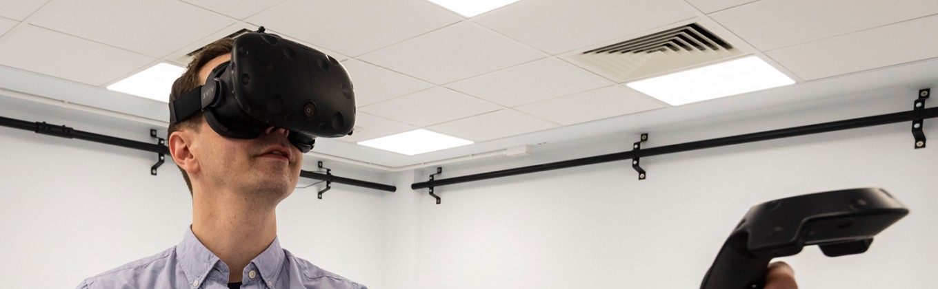A man using a virtual reality headset in the Psychology extended reality suite.