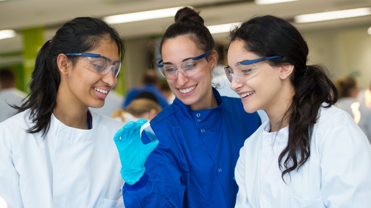 Supervisor showing students vial of liquid